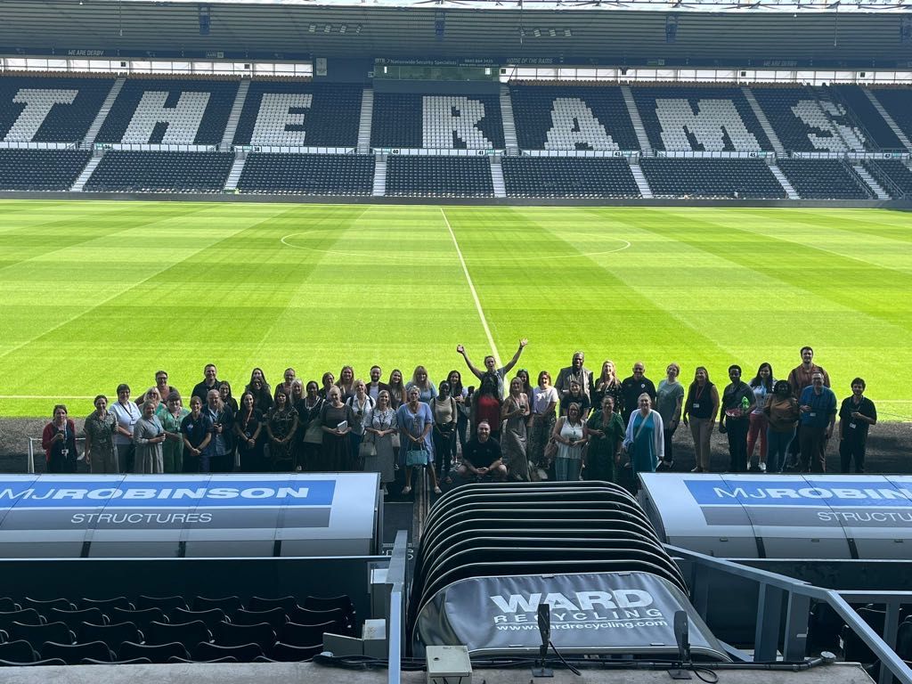 Photo of the YA / CYPN meeting attendees on the Derby County pitch-side